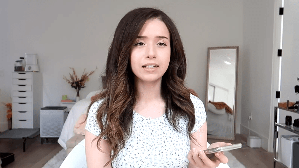 Pokimane in white shirt holding phone