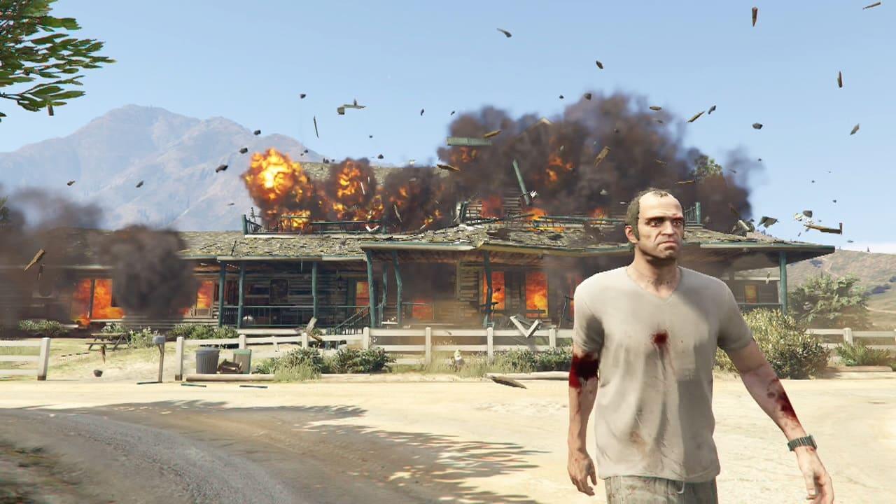 An image of Trevor walking away from an exploding building in GTA 5.