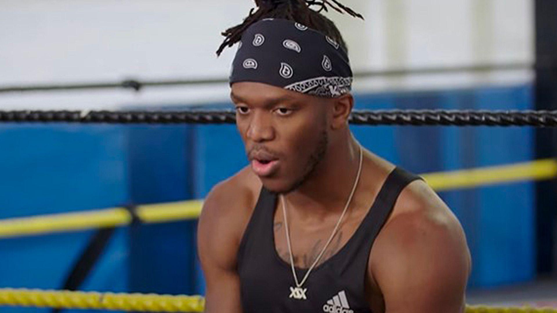 KSI sat on ring in black athletic vest and bandana