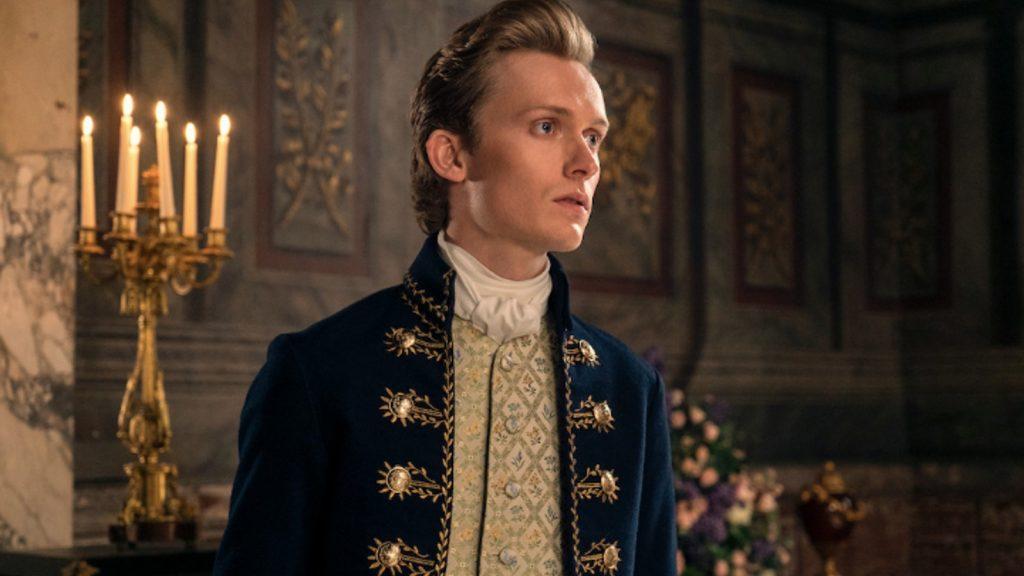 Reynolds wears a coat with shiny buttons in Queen Charlotte: A Bridgerton Story