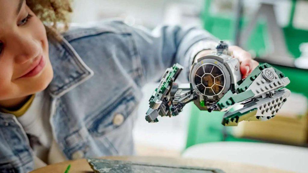 A child playing with the LEGO Star Wars Yoda's Jedi Starfighter .