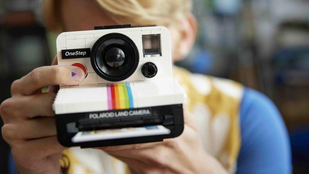 Adult with their LEGO-reimagined Polaroid camera.