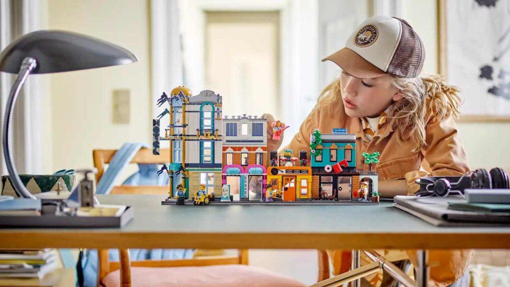 A child playing with their LEGO Creator 3in1 Main Street set