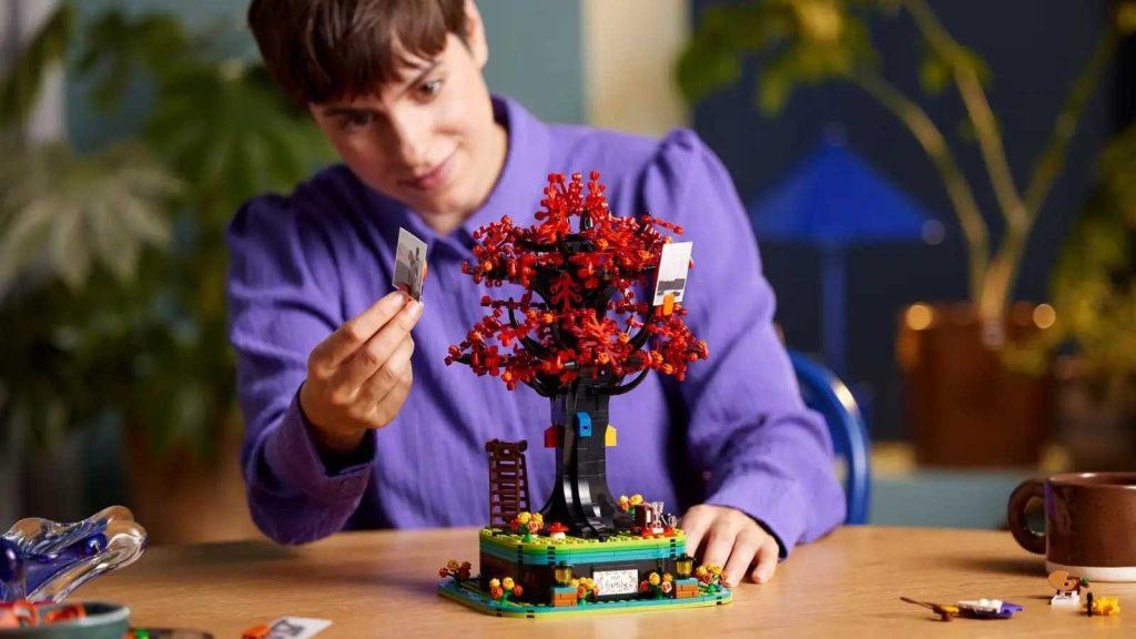 An adult with their LEGO Ideas Family Tree set that will be released in February 2024