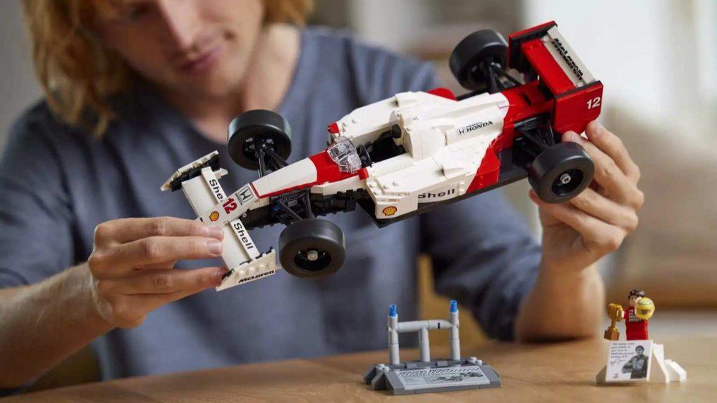 An adult with their LEGO Icons McLaren MP4/4 & Ayrton Senna set