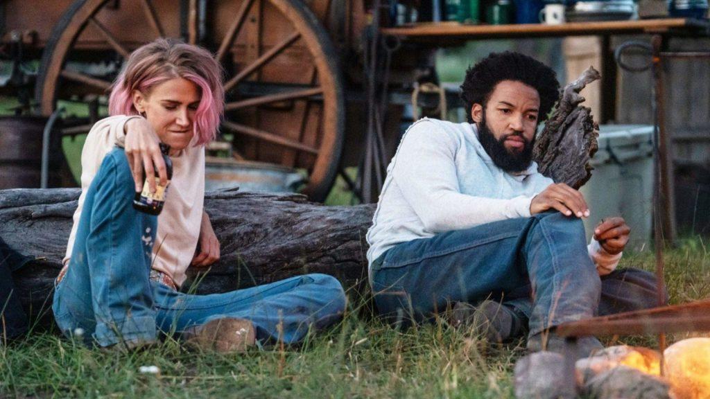 Teeter and Colby in Yellowstone laying on the grass by a wagon wheel