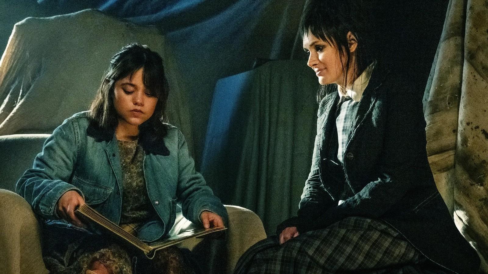 Jenna Ortega reading a book next to Winona Ryder in Beetlejuice Beetlejuice.