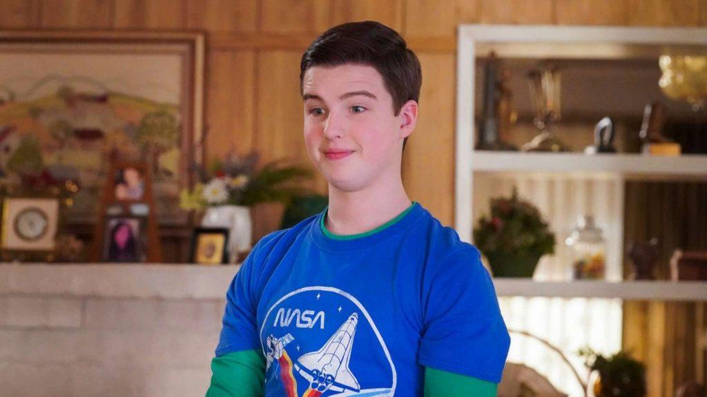 Iain Armitage as Sheldon Cooper, wearing a blue t-shirt