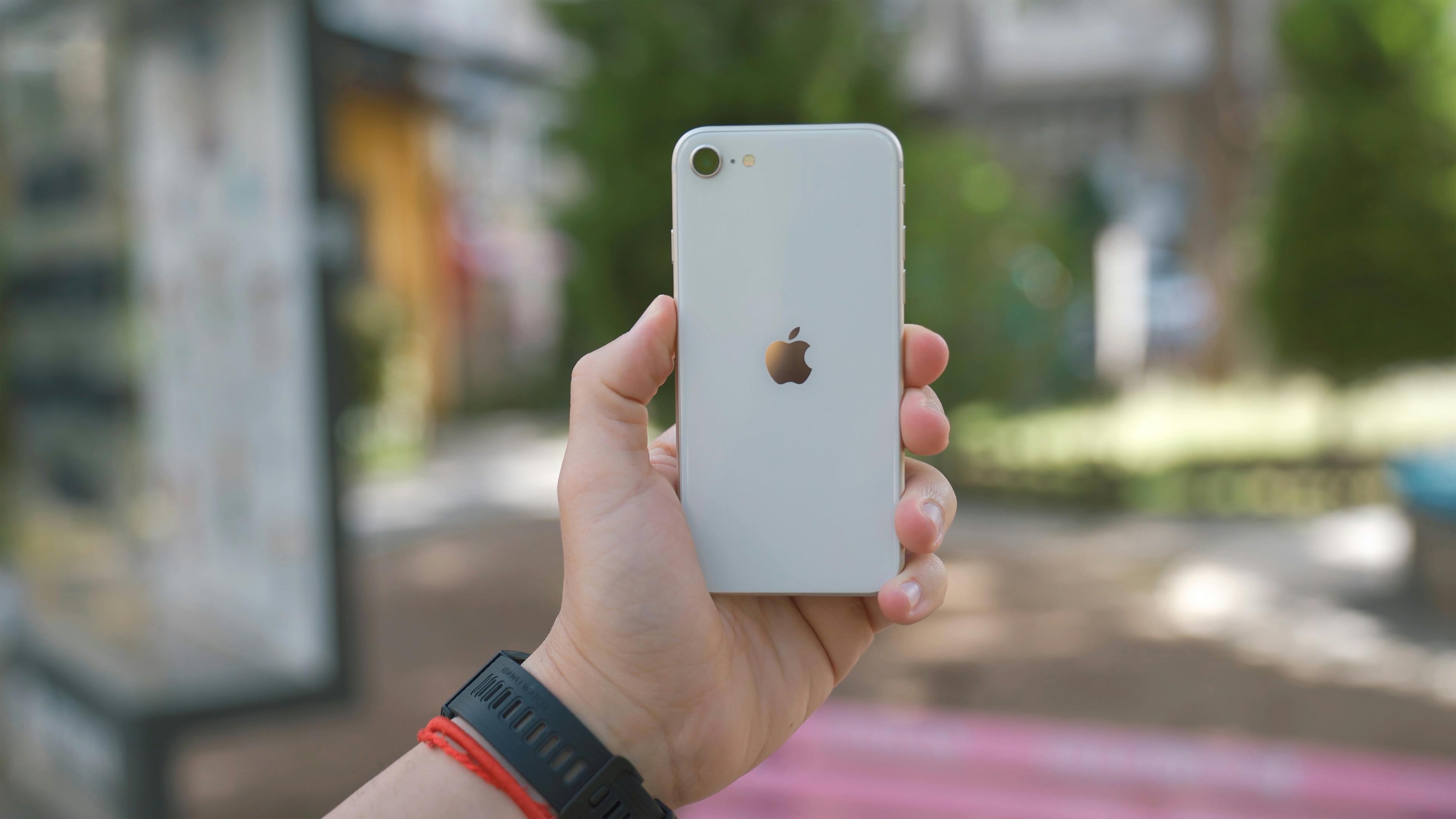 iPhone SE 2022 in the hands of a user against a blurred background