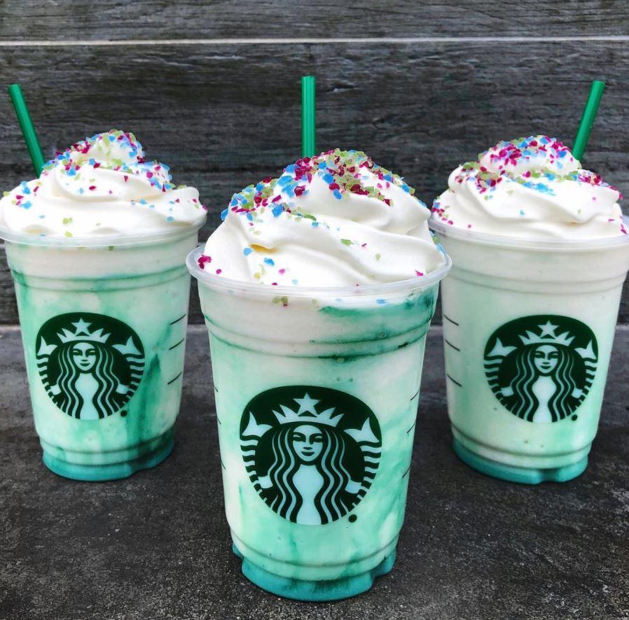 Three blue swirled starbucks frappuccionos with cream on top