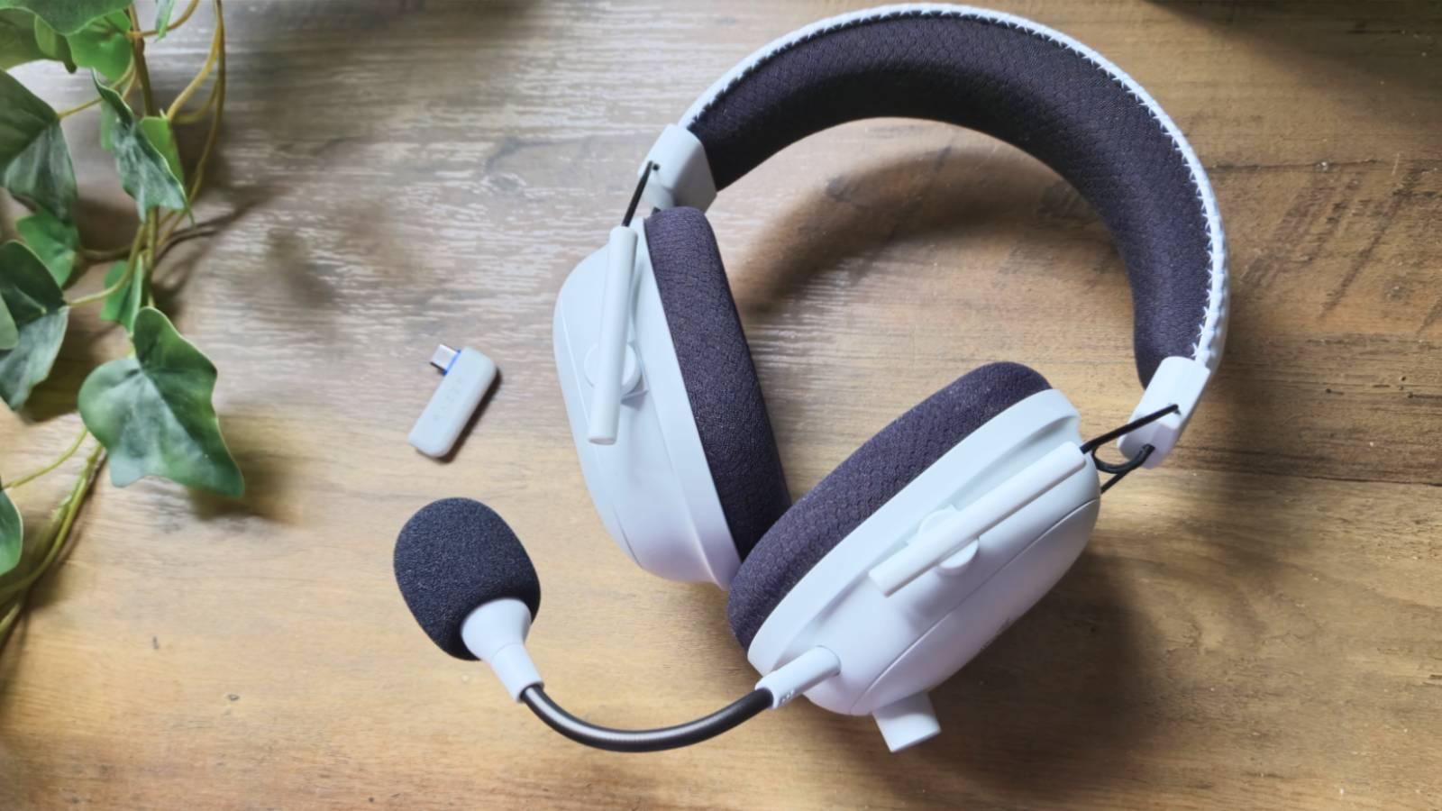 Photo of the Razer BlackShark V2 Pro White Edition gaming headset for PS5 on a wooden table.