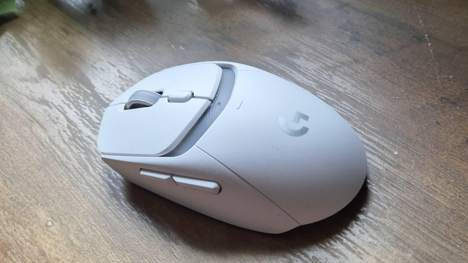 Custom photo of the Logitech G309 mouse on a wooden table.