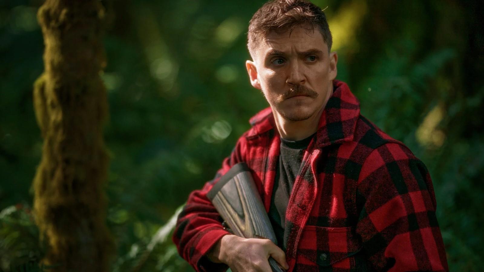 Kyle Gallner carrying a shotgun in Strange Darling.