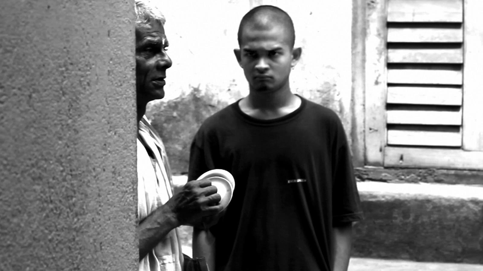 Gandu speaking with a man on the street