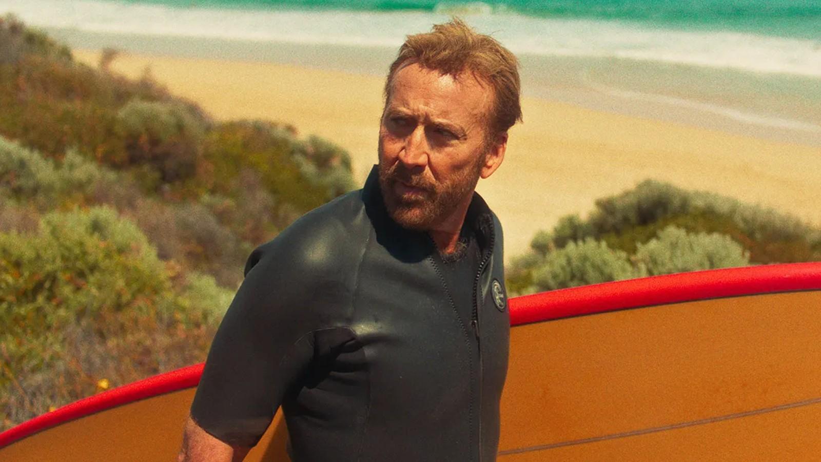 Nicolas Cage with his surfboard in The Surfer.