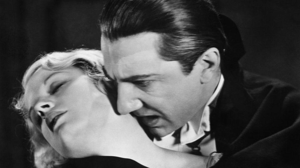 Bela Lugosi bites a woman's neck in Dracula.