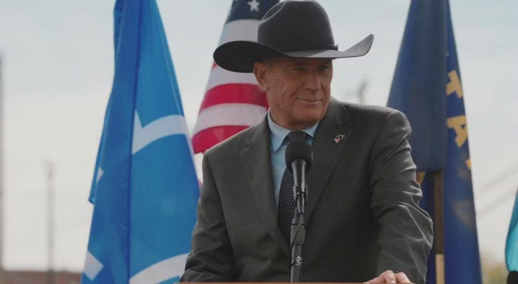 Kevin Costner as John Dutton in Yellowstone standing behind a podium