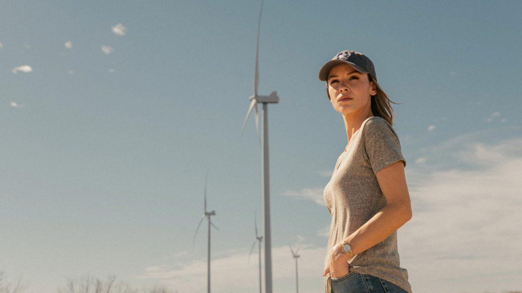 Rebecca stands under a wind turbine in Landman