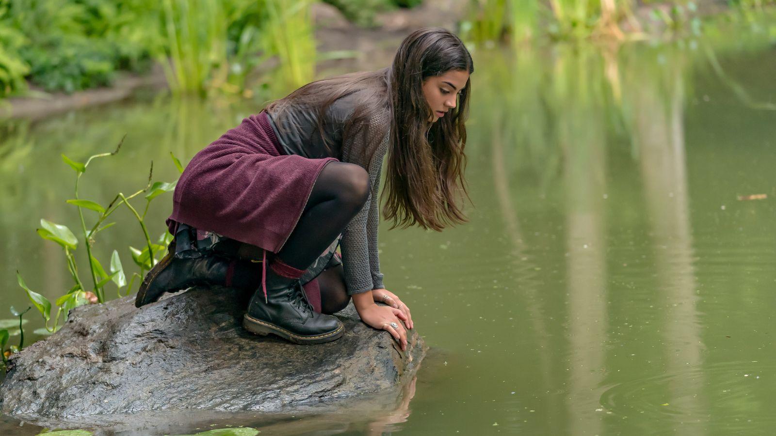 Alice crouches down at the pond in The Way Home Season 3